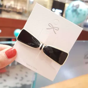 Black and white acrylic bow hair clip detail shot, elegant daily hair accessory for women.