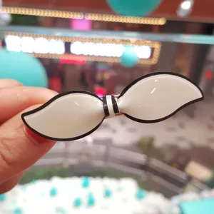 Detail shot of white acrylic hair clip with black edge, bow shape side clip for women.