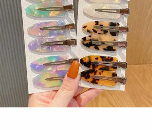 Detailansicht bunter Acetat Entenschnabel Haarklammern auf weißer Karte, glattes Design.