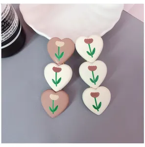 Detailed close-up of cute heart-shaped hair clips with floral patterns, chic hair accessories.