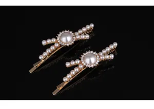 Close-up detail of exquisite gold hair clips decorated with pearls and sparkling rhinestones.