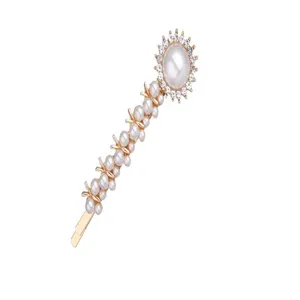 Close-up detail of the elegant pearl and rhinestone hair clip with a gold-tone base.