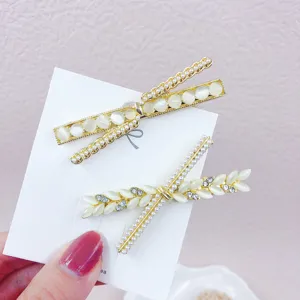 Elegant cat-eye stone pearl hair clips set, gold tone metal side hairpins for women styling.