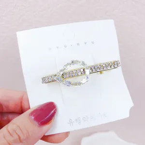 Dettaglio fermaglio per capelli geometrico in strass dorato, accessorio elegante.