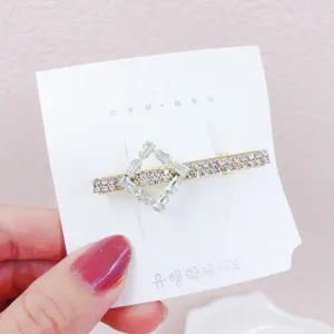 Elegante molletta geometrica con strass su cartoncino bianco per styling quotidiano.