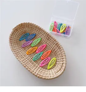 Colorful geometric children hair clips closeup detail display inside a woven basket