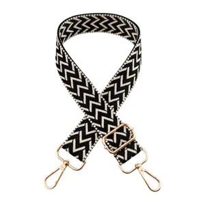 Tracolla per borsa a motivo chevron nero e bianco con accessori dorati, ampia cinghia regolabile.