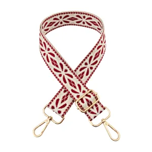 Wide woven bag strap replacement with red white geometric embroidery and gold hardware adjusters.