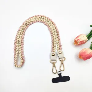 Vue détaillée de la lanière de téléphone tressée et sangle de sac en rose et beige avec clips.