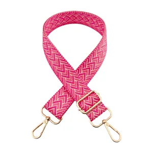 Vista dettagliata della tracolla per borsa larga in tessuto con motivo chevron rosa e accessori dorati.