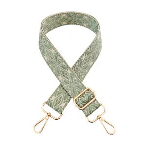 Close-up of woven bag strap detail featuring green leaf pattern and shiny gold metal hardware.
