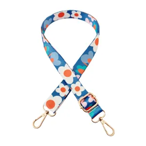 Gedetailleerd overzicht van de blauwe bloemen vervangende tasriem met gouden hardware.