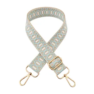Close-up detail of blue geometric jacquard bag strap with elegant gold hardware buckles.