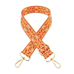Detailed view of wide woven replacement bag strap with orange geometric pattern and gold hardware.