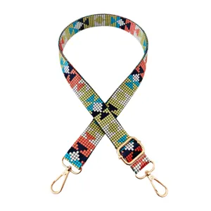 Gedetailleerd overzicht van de kleurrijke schouderband met pixelpatroon, gouden gespen en haakjes.