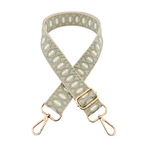 Woven bag strap detail view, adjustable jacquard shoulder strap with gold metal hardware.