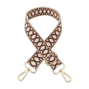 Detailed view of brown and white geometric jacquard replacement bag strap with gold hardware.
