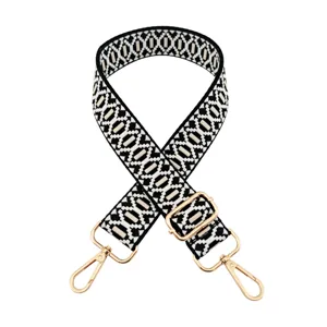 Detail view of black white geometric woven replacement bag strap with gold metal hardware.