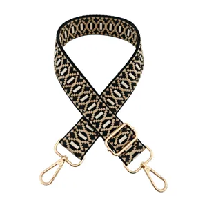 Detailed view of the woven jacquard replacement bag strap with adjustable gold metal hardware.