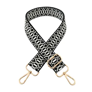 Detailed view of the black and white geometric jacquard replacement bag strap with gold metal hardware.
