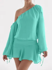 Vista detallada de un vestido de gasa verde menta de un hombro con mangas largas y volantes.