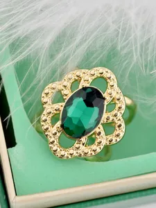 Vintage openwork lace scarf buckle detail showing green oval crystal and gold flower frame.