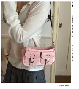 Primo piano della borsa a spalla rosa vintage con due tasche frontali e fibbie in metallo.