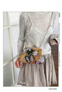 Borsa a tracolla vintage ricamata a fiori con chiusura a bacio e catena in metallo.