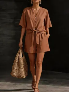 Casual brown short-sleeve V-neck button-down shirt and tie-waist shorts outfit detail.