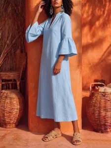 Close-up detail of the light blue bell sleeve V-neck midi dress in warm interior scene.