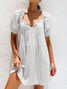 Vestido blanco escalonado con cuello en V, mangas abullonadas y cordón para verano.