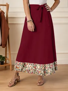 Jupe longue élégante pour femme avec ourlet à imprimé floral et lien de serrage.
