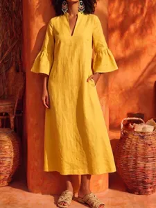Detailed view of the yellow linen midi dress showcasing its elegant V-neck and bell sleeves.