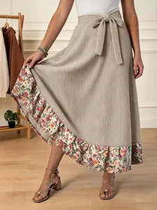 Vue détaillée de la jupe longue beige côtelée pour femme avec ourlet fleuri et lien.