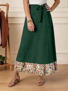 Vue détaillée de la jupe maxi verte côtelée pour femmes avec un ourlet floral et un nœud.