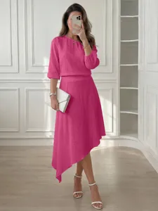 Conjunto informal elegante de color rosa con top de hombros descubiertos y falda midi.