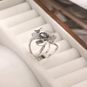 Primo piano dell'elegante anello per sciarpa floreale con cristalli brillanti e pietra scura.