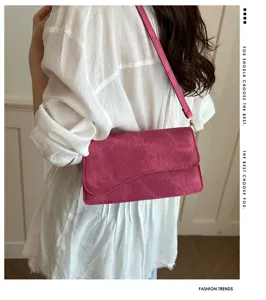 Gedetailleerd overzicht van stijlvolle roze schoudertas met gebogen flap en hardware.