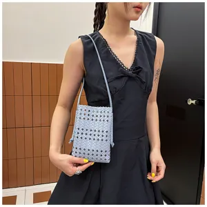 Vue détaillée du sac bandoulière mini tressé ajouré à la mode porté par le mannequin.