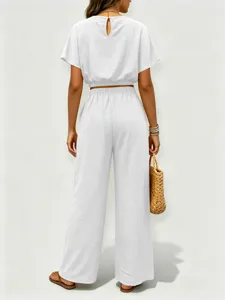 Detalles cercanos del top liso con cuello redondo y pantalones anchos elegantes.