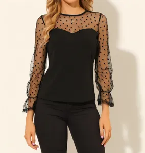 Detalle en primer plano de la blusa transparente de manga larga con bonito motivo de corazones.