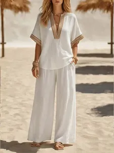 Beachwear detail shot featuring stylish two-piece v-neck top and wide-leg trousers.