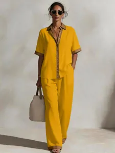 Vista dettagliata della elegante camicia a maniche corte gialla con pantaloni abbinati.