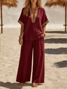 Wine red casual two-piece set with V-neck top and wide-leg trousers detail shot.