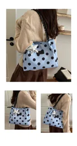 Vista dettagliata della borsa a tracolla elegante a pois azzurri con manico intrecciato.