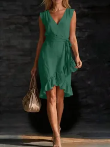 Green sleeveless v-neck wrap dress detail showing asymmetric ruffle hem and waist tie.