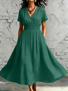 Vista dettagliata dell'elegante abito verde scuro con scollo a V e vita elasticizzata.