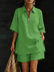 Detailed view of green short sleeve zipper top and loose shorts, casual summer two piece outfit.