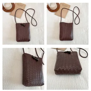 Detailed view of dark brown woven mini crossbody phone bag, showing delicate texture and craftsmanship.