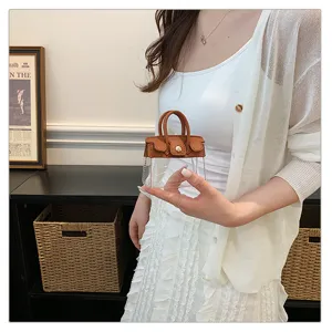 Vista detallada del mini colgante de bolso para llaves con diseño transparente y cuero marrón.